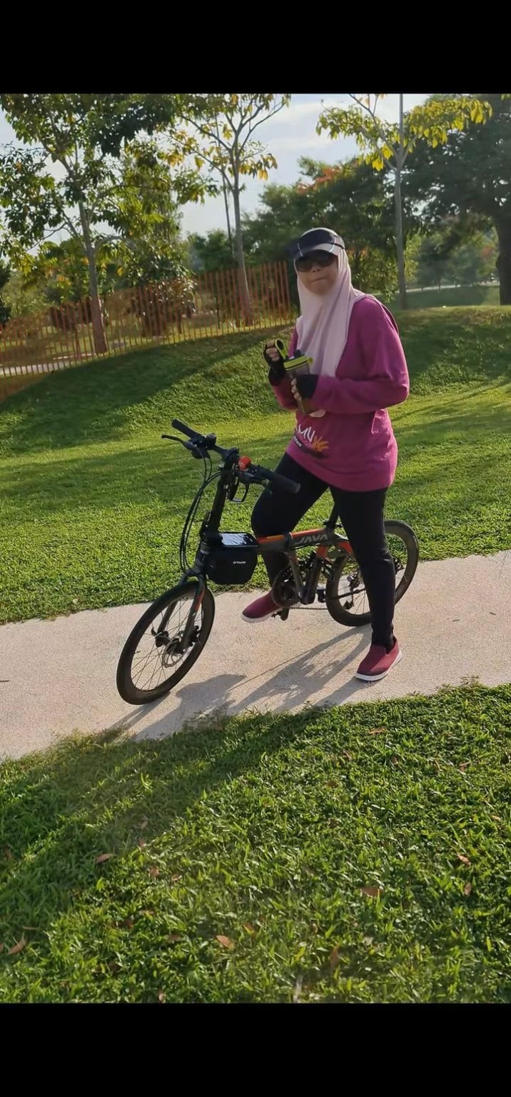 Kak Sukma bersama basikal di taman.